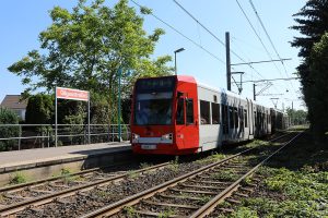Ansicht der KVB-Haltestelle Gilgaustraße mit einfahrender Bahn