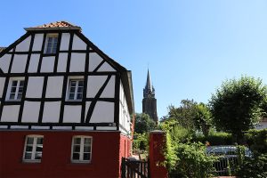 Fachwerkhaus mit Kirche im Hintergrund
