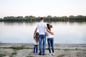 Eine Familie steht am Rheinufer und schaut aufs Wasser