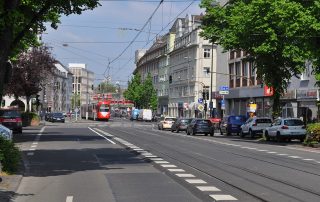 Hauptverkehrsstraße mit Straßenbahn und fahrenden Autos